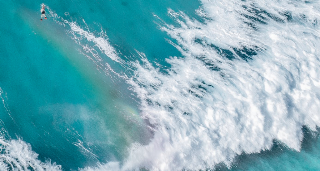 Large ocean wave flowing forward with surfer